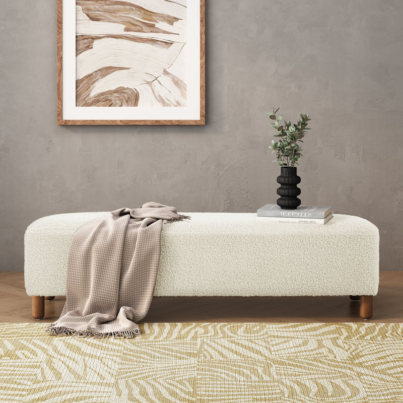 White upholstered ottoman bench with smooth rounded top and wooden legs