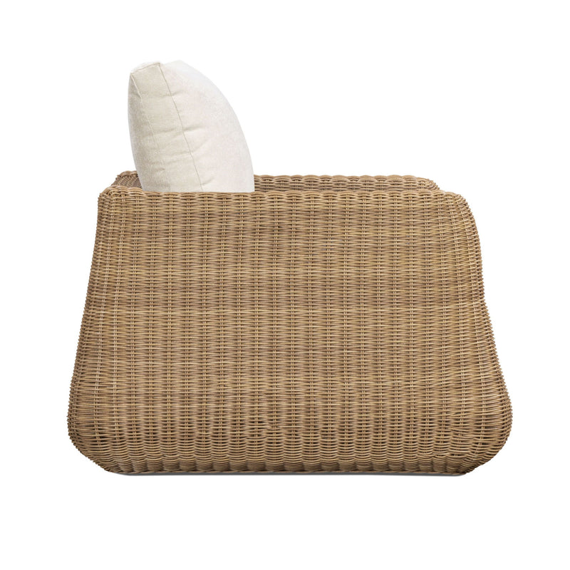 Outdoor accent chair with white back pillow and woven wicker base