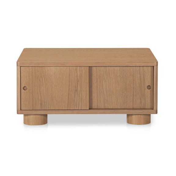 Natural wood storage coffee table with two front cabinet doors and thick turned legs