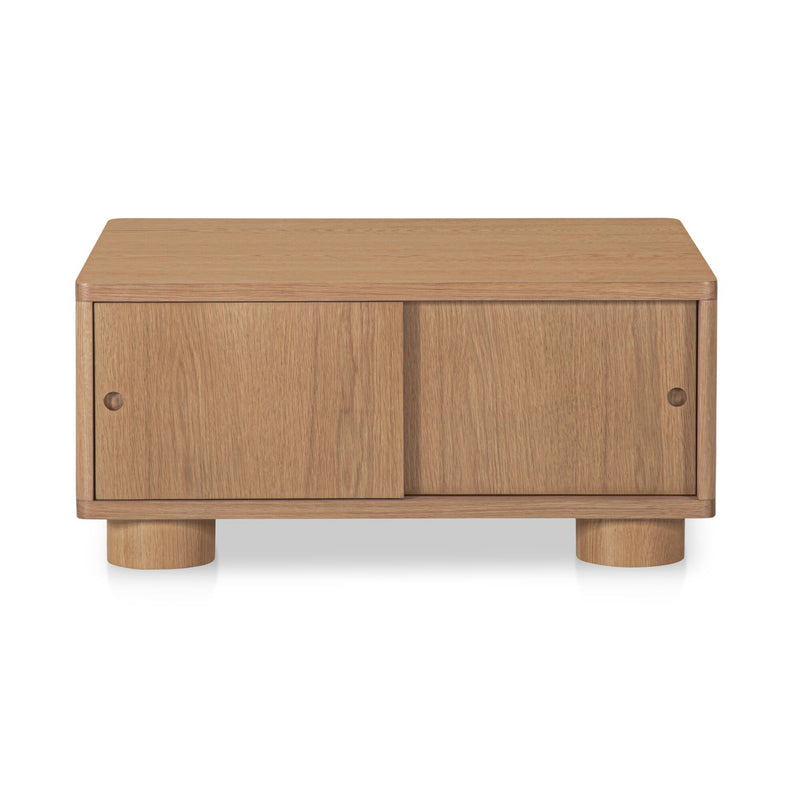 Natural wood storage coffee table with two front cabinet doors and thick turned legs
