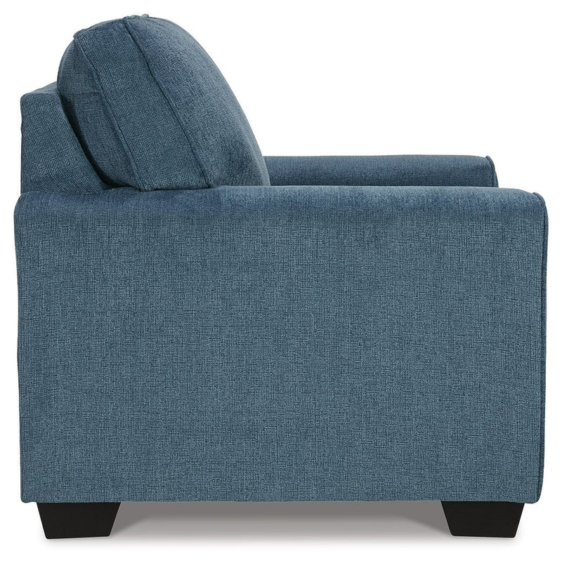 Blue upholstered accent chair angled view, showing tall back and padded armrests