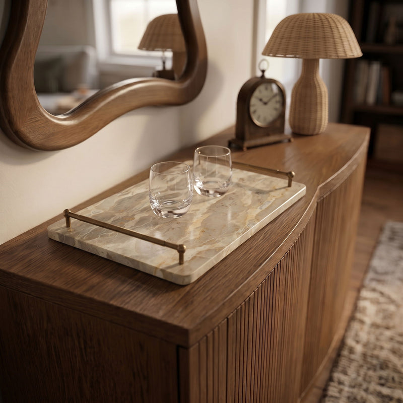 Light beige marble serving tray with brass corner handles and two clear glasses.