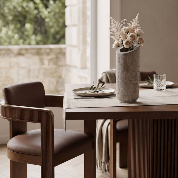 Beige travertine vase with bouquet on a table