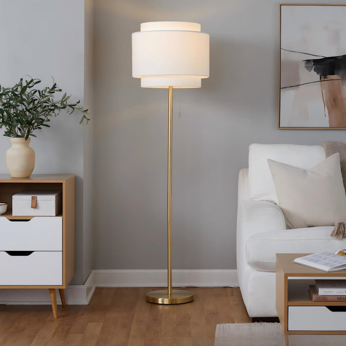 Gold-tone contemporary floor lamp with white fabric drum shade and round base