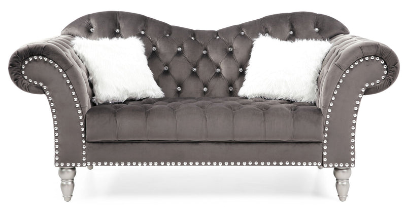 Dark gray velvet round arm loveseat with tufted back, nailhead trim, faux fur pillows.