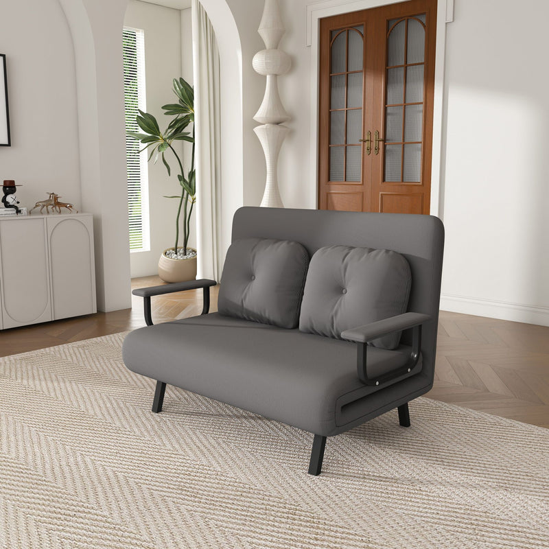 Convertible sofa bed, dark gray fabric with two bolsters and black metal legs.