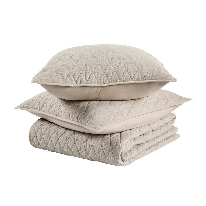 Stack of natural-toned quilt and pillows with diamond quilting, folded set
