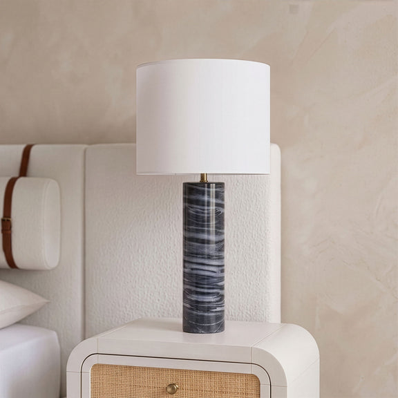 Textured fabric table lamp with white drum shade and dark gray marbled cylindrical base