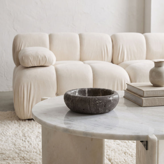 Gray genuine travertine tray with shallow round bowl and speckled travertine texture.