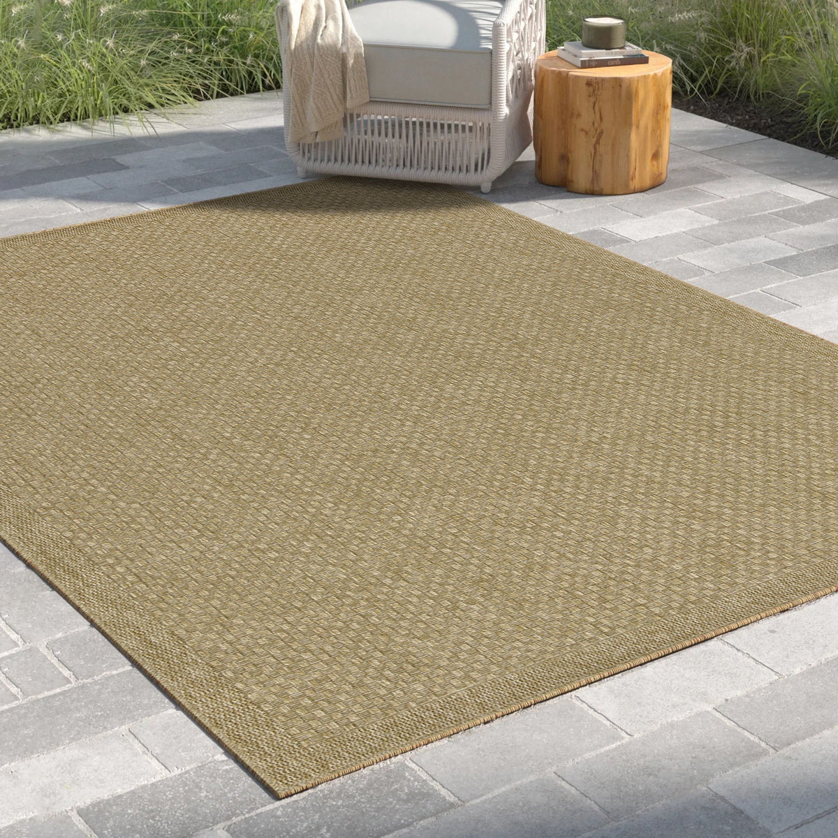Beige jute area rug laid outdoors, angled view showing flat weave and edge