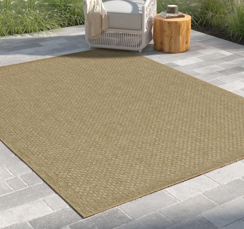 Beige jute area rug laid outdoors, angled view showing flat weave and edge