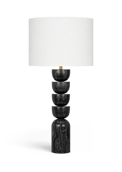 Table lamp with stacked dark marble base and white fabric drum shade, brass accents
