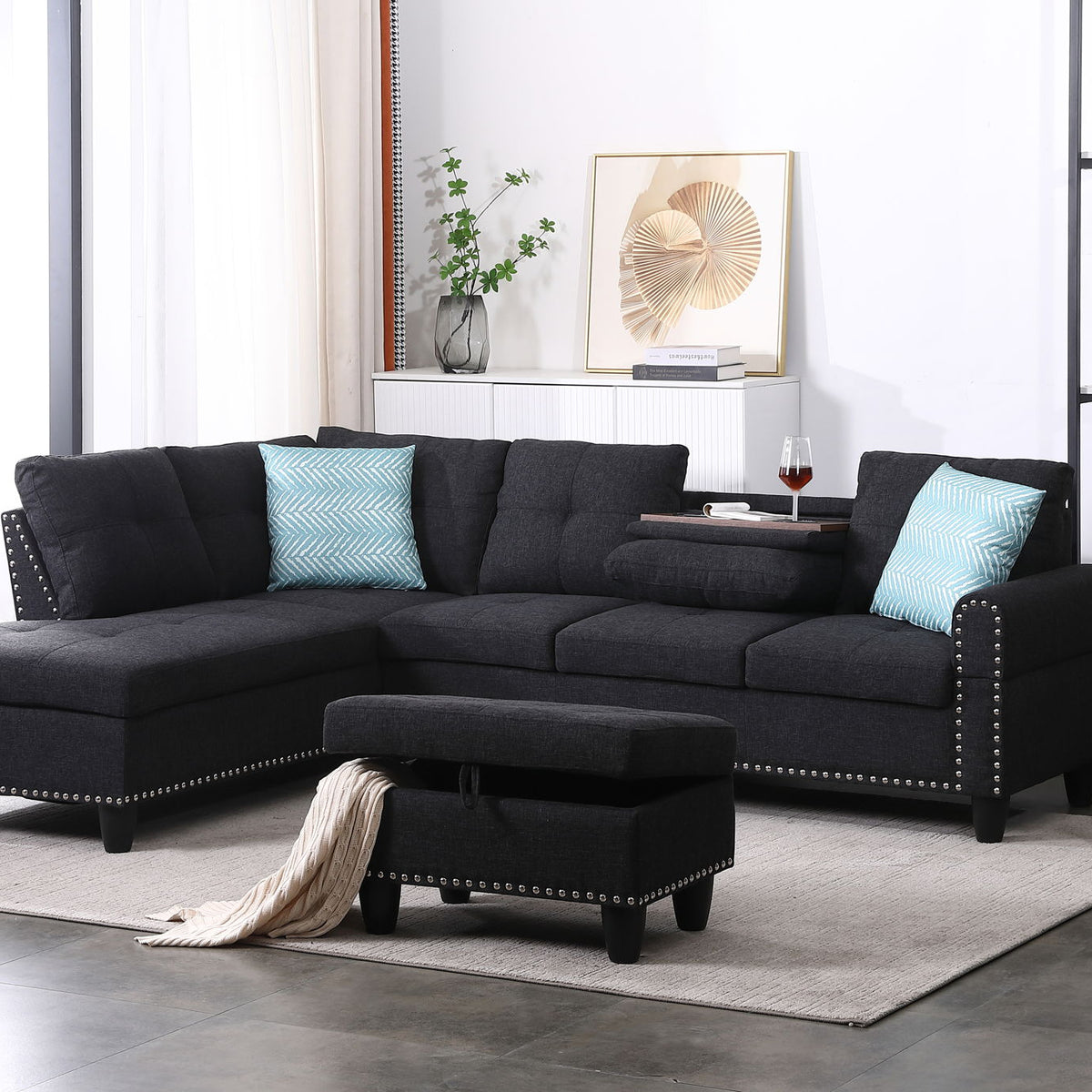 Dark gray sectional sofa with left-facing chaise, ottoman and blue accent pillows