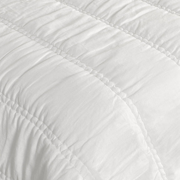 White quilt close-up with raised channel stitching and quilted texture