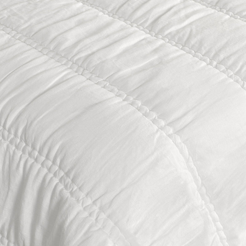 White quilt close-up with raised channel stitching and quilted texture