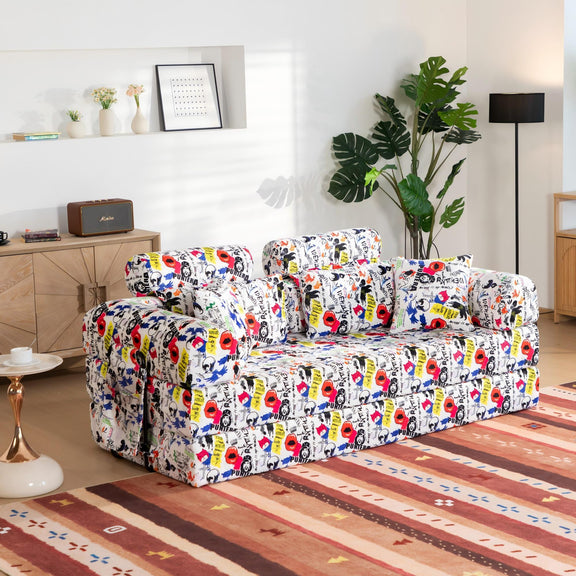 White convertible sleeper sofa with colorful graffiti print upholstery and armrest pillows