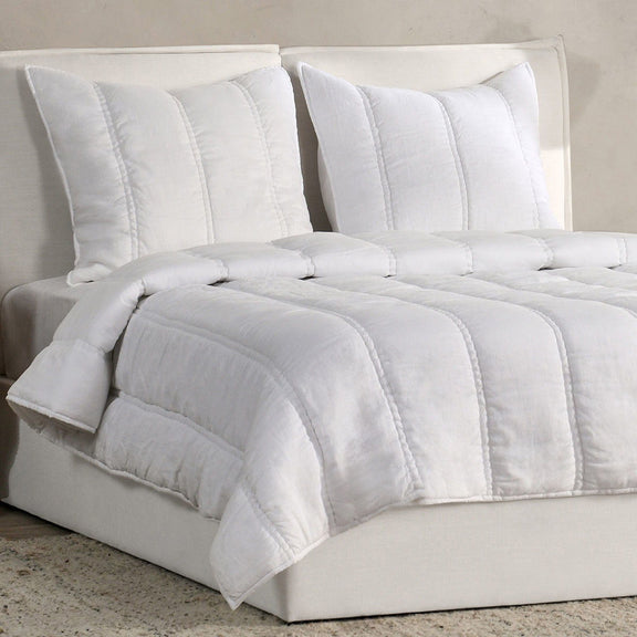 White pillow shams with vertical channel stitching on a bed