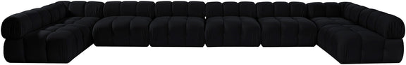 Black modular sectional sofa with tufted, padded seats and curved corner chaise