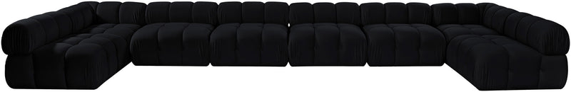Black modular sectional sofa with tufted, padded seats and curved corner chaise