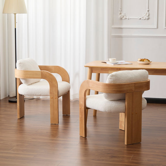 Pair of dining chairs with curved wood arms, cream cushions, and pillow backs
