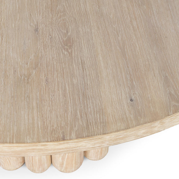 Cream washed round dining table close-up of underside and vertical pedestal slats.