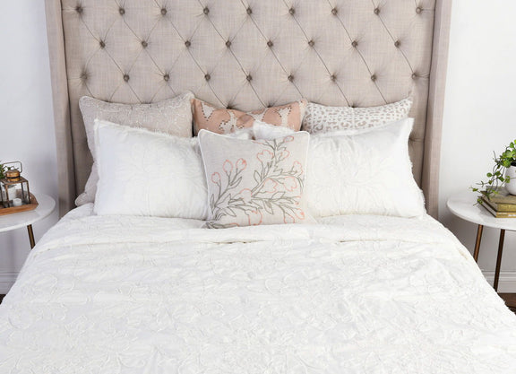 Antique cream standard sham with textured floral weave, plus blush floral accent cushion