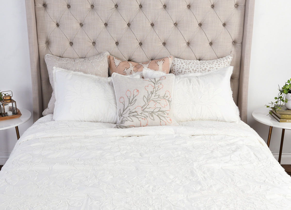 Antique cream comforter with decorative quilted swirl texture on bed