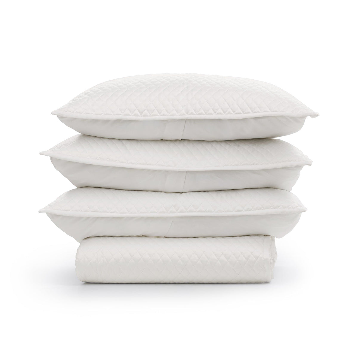 Stack of quilted white throw pillow shams with diamond pattern texture