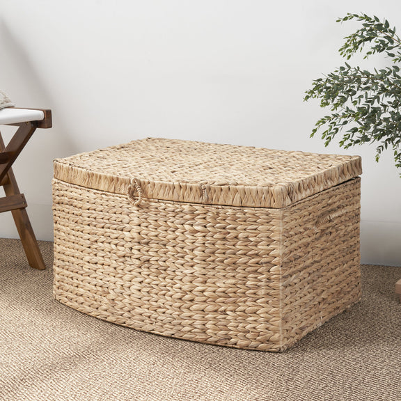 Light brown woven storage trunk with a fitted lid and front loop handle