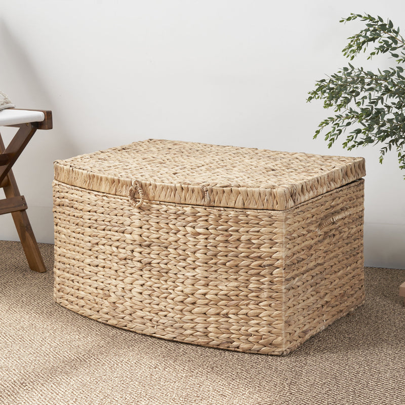 Light brown woven storage trunk with a fitted lid and front loop handle