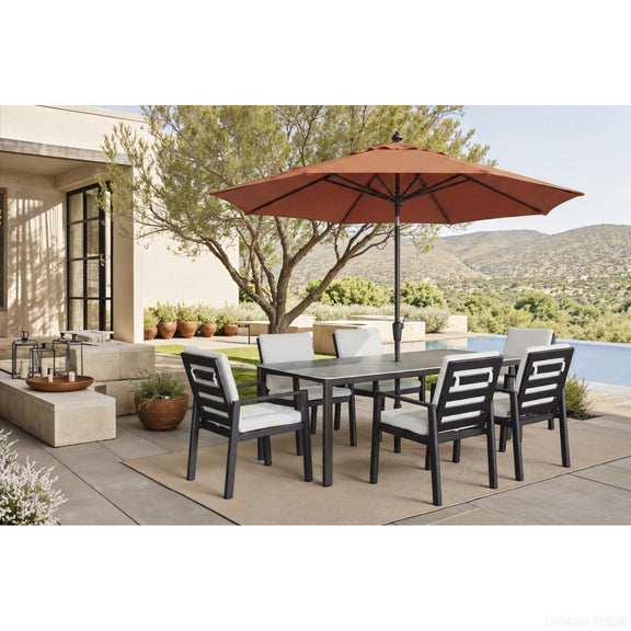 Outdoor dining table with gray top and dark legs, surrounded by matching chairs.