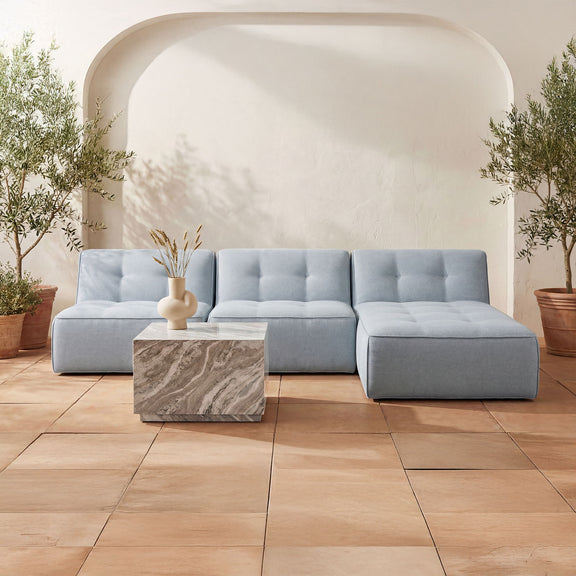 Light blue upholstered outdoor chaise lounge with tufted back and modular seat