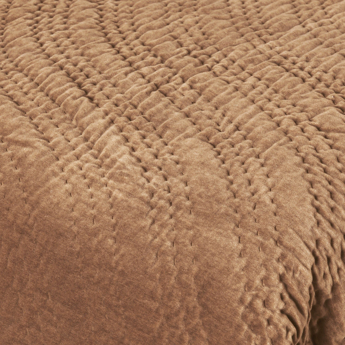 Brown quilted velvet fabric with raised diamond texture close-up