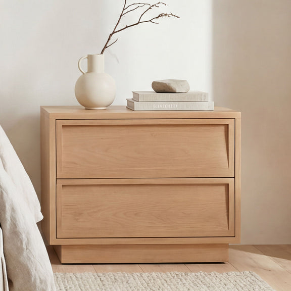 Natural wood two-drawer nightstand with wide top and recessed drawer panels