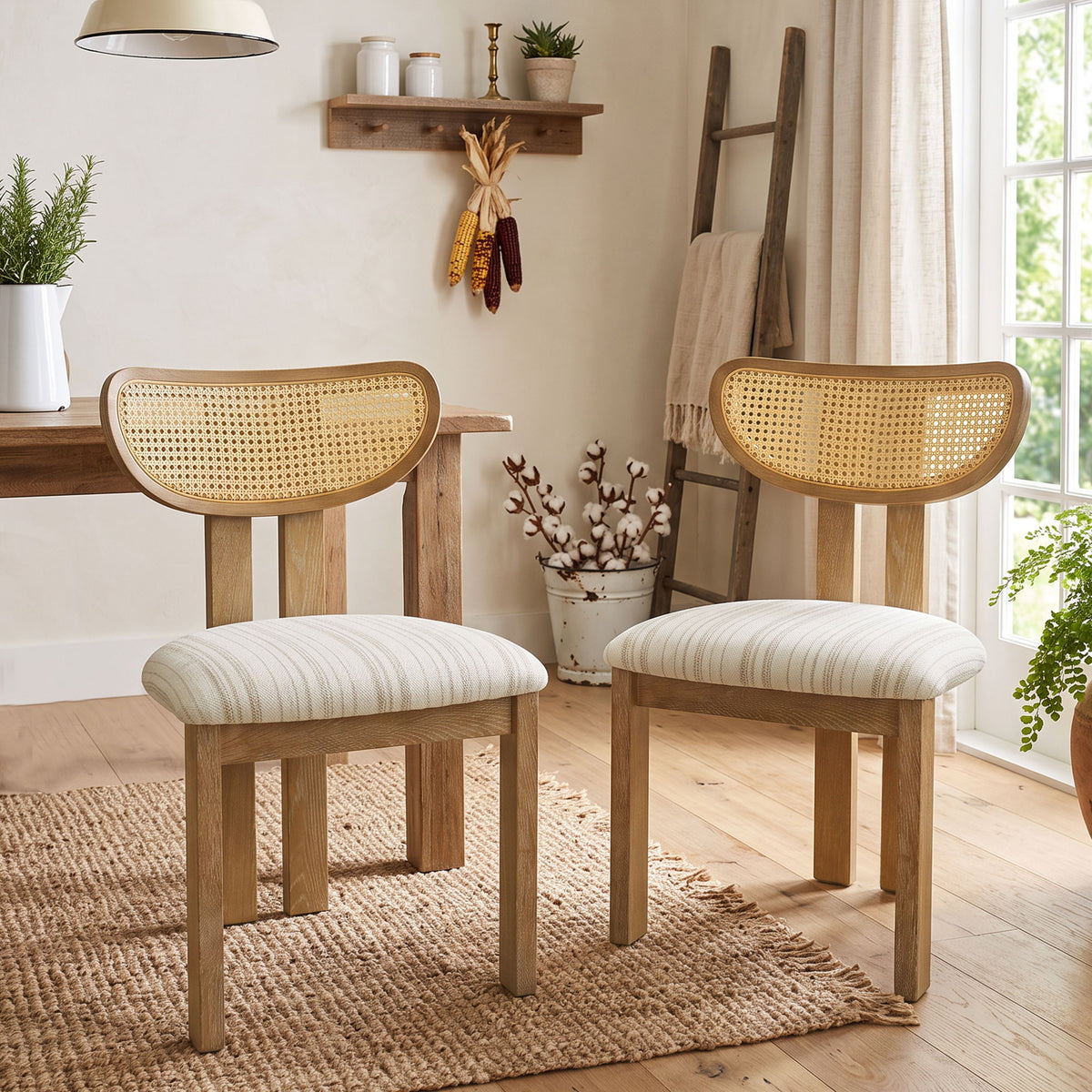 Pair of dining chairs with woven rattan backs, striped upholstered seats, and light wood frames