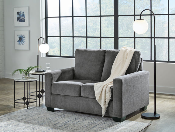Dark gray fabric sofa with square arms, three seat cushions, and a light throw blanket