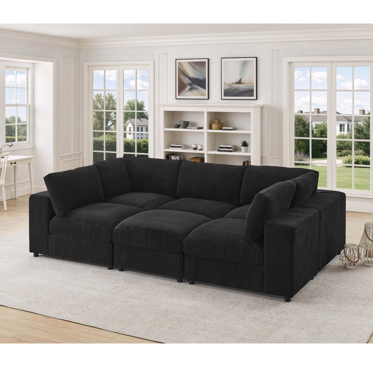 Black modular sectional sofa with deep cushions, padded arms, and ottoman-style chaise