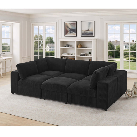 Black modular sectional sofa with deep cushions, padded arms, and ottoman-style chaise