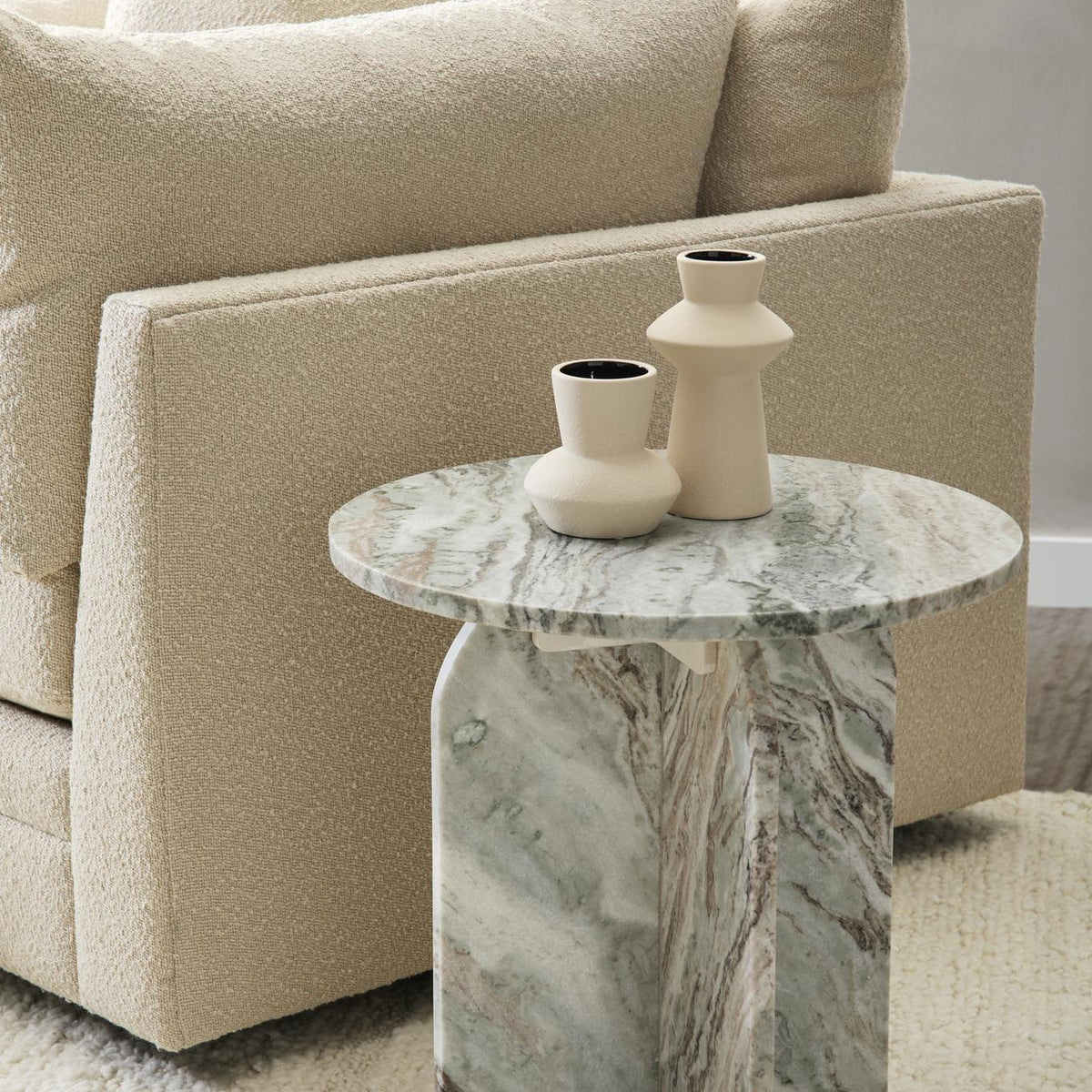 Gray marble round table with pedestal base and decorative vase on top