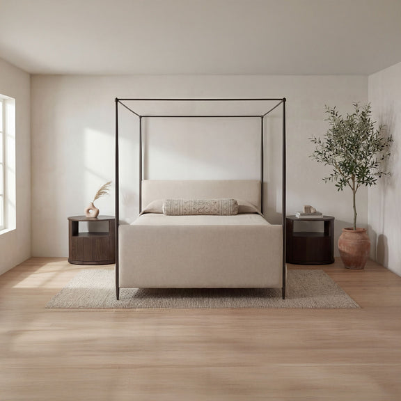 Beige king bed with black metal canopy frame, platform base, and pillow