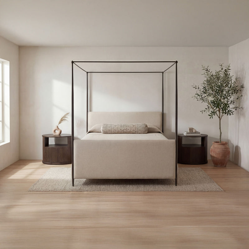 Beige king bed with black metal canopy frame, platform base, and pillow