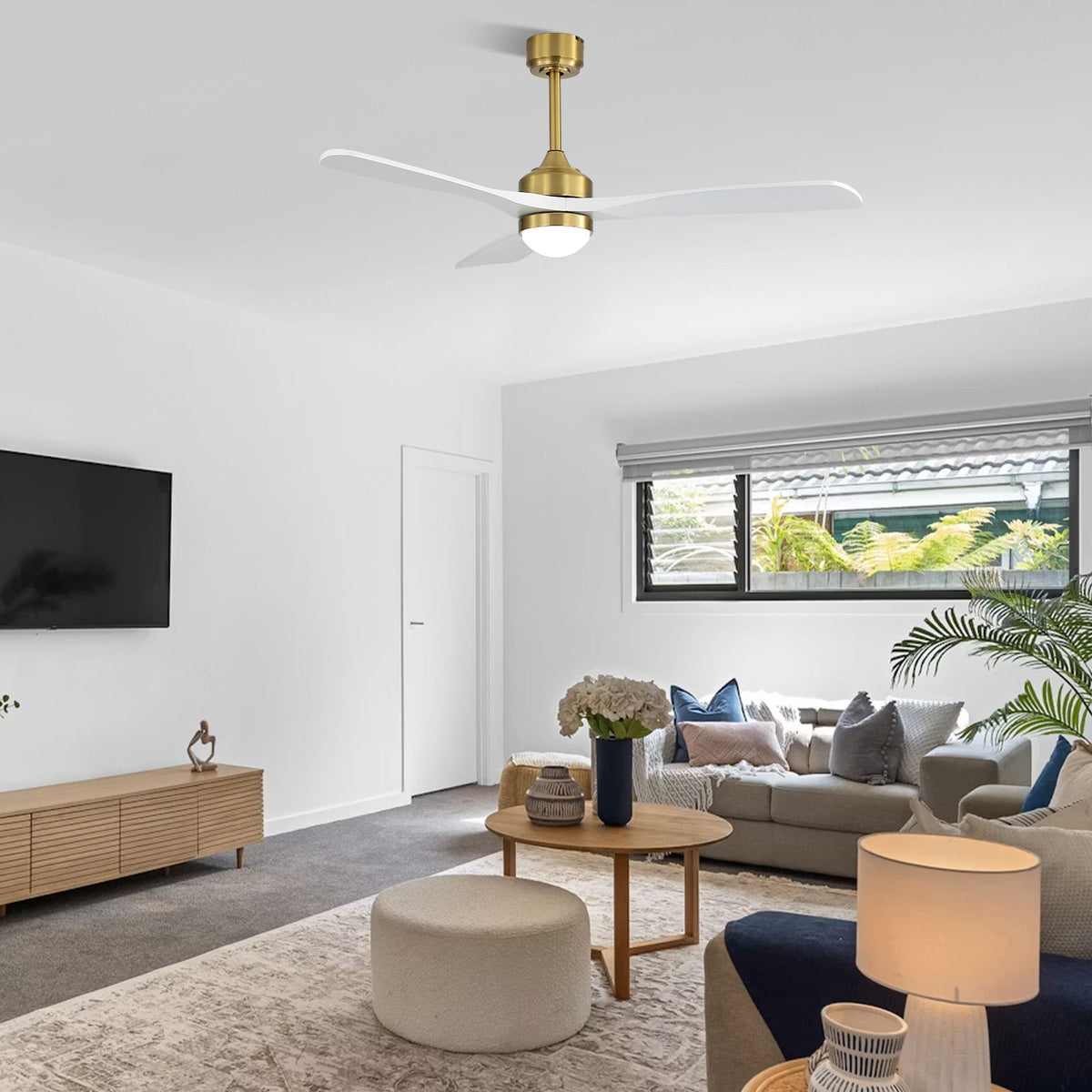 Gold and white ceiling fan with light overhead in a living room