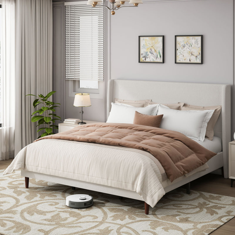 Upholstered bed with tall white headboard, white bedding, and brown quilt