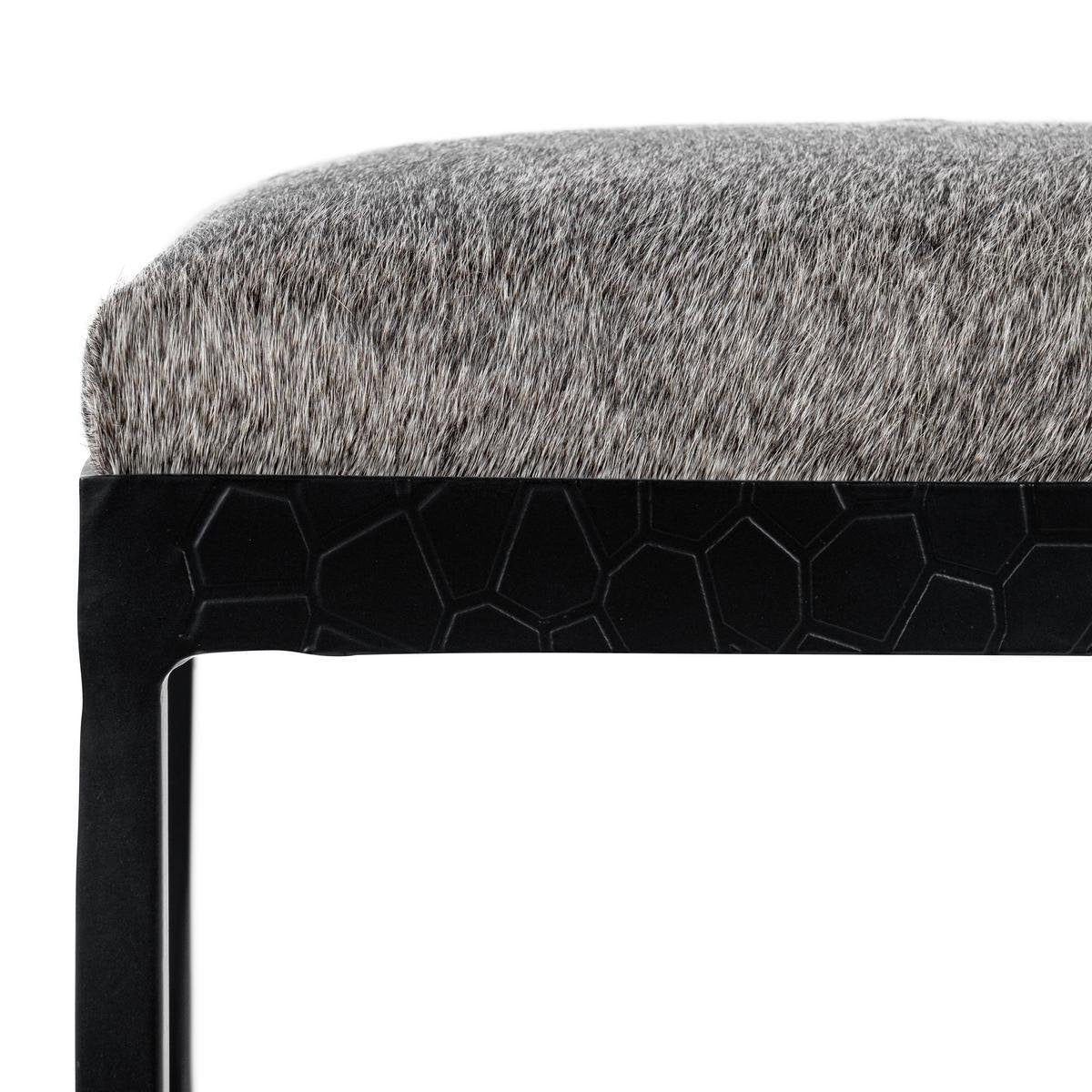Gray upholstered stool seat with dark honeycomb-style side panel