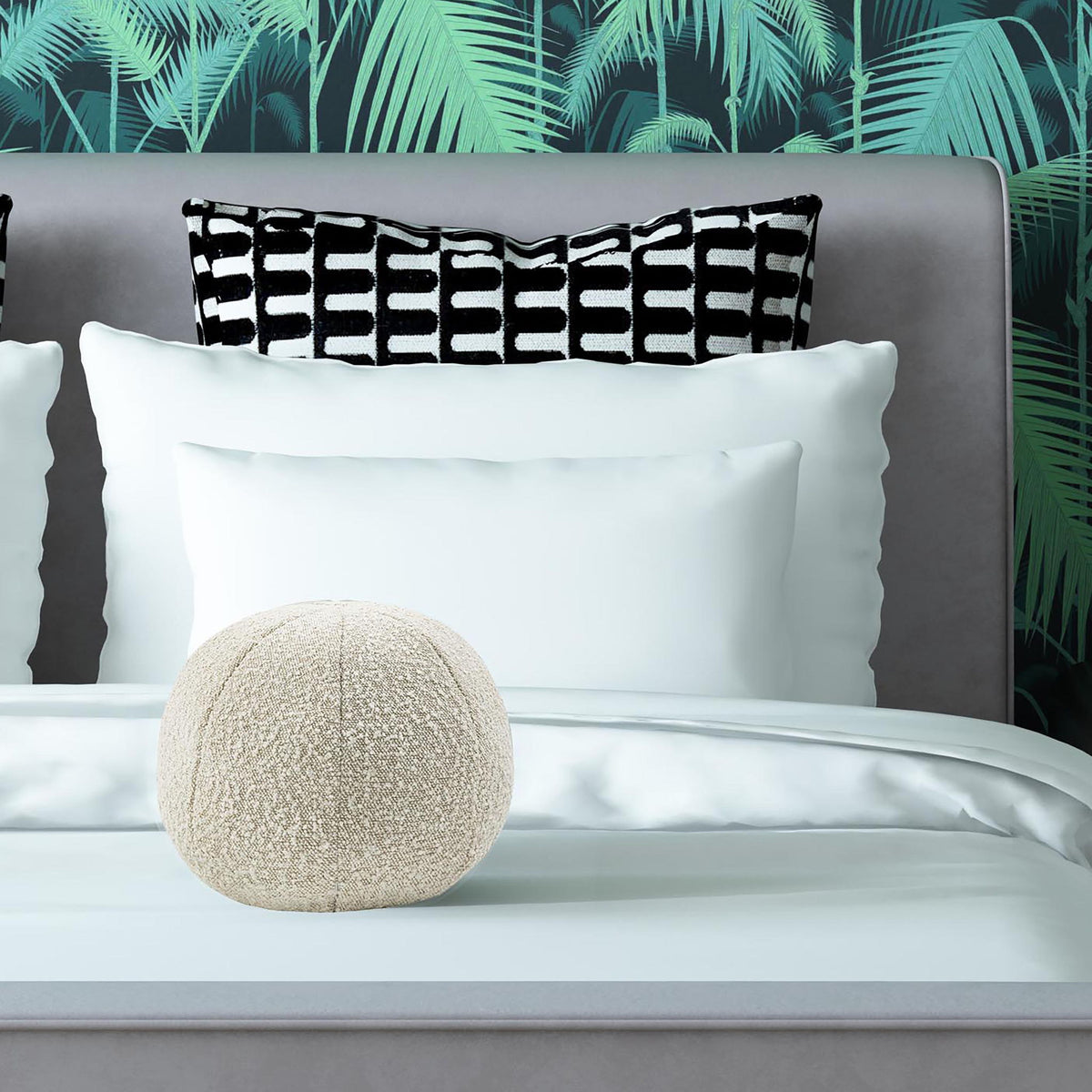 Beige round textured pillow on a bed, with patterned accent pillow behind it.