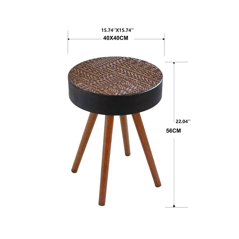 Round coffee table with carved patterned top, dark base, and three brown tapered legs