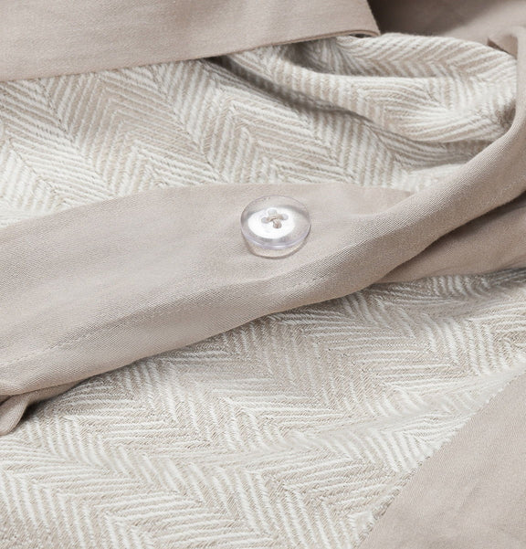 Natural French herringbone duvet close-up with textured chevron weave and fabric button