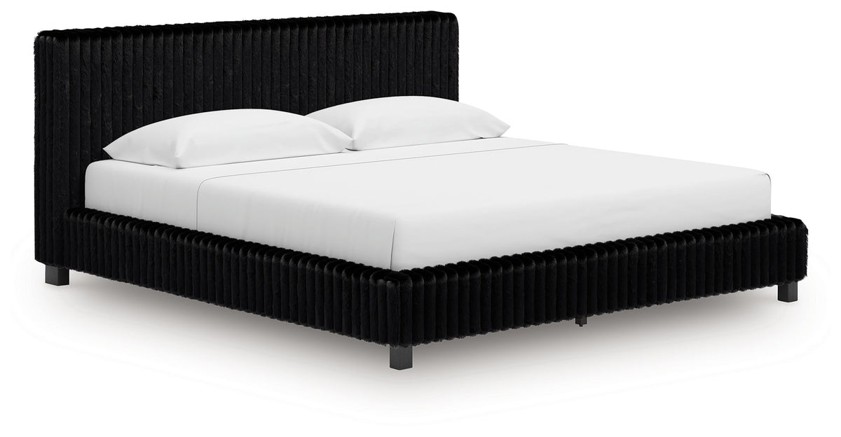 Black upholstered bed frame with tall ribbed headboard and white bedding.