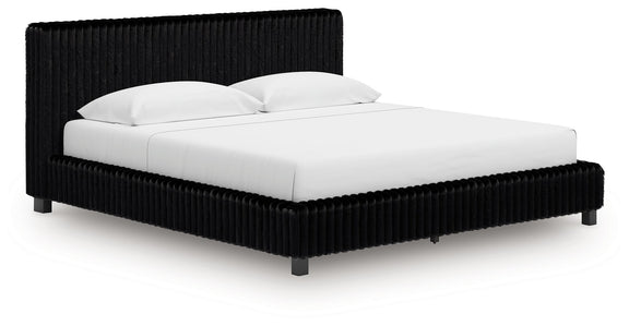 Black upholstered bed frame with tall ribbed headboard and white bedding.