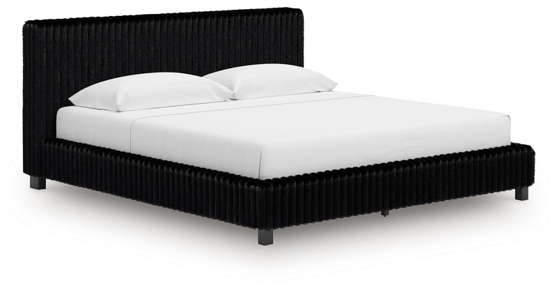 Black upholstered bed frame with tall ribbed headboard and white bedding.